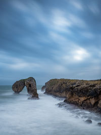 Rocks in sea against sky