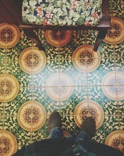 Low section of man standing on tiled floor