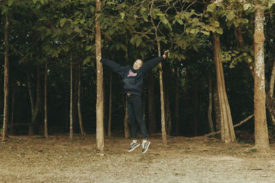 Man with arms raised in forest