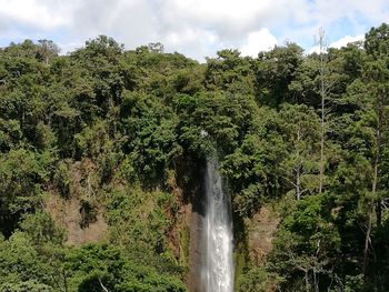 Scenic view of waterfall against sky