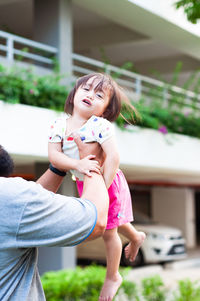 Father playing with daughter at park