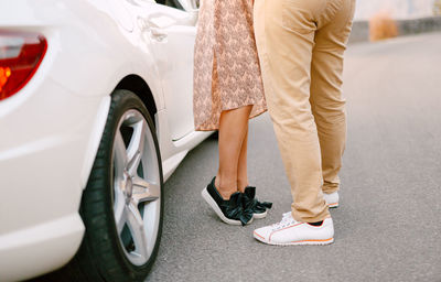 Low section of woman standing in car