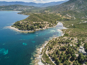 High angle view of sea by mountains against sky