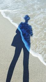 Shadow of woman on sand at beach