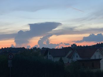 Houses in town against sky during sunset