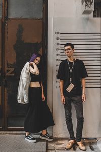 Portrait of young man standing against wall
