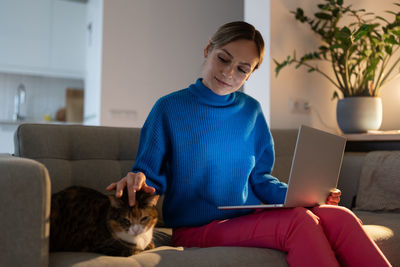 Cute cat inspires woman owner to work productively on project and new ideas. care and love for pets.