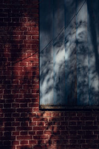 Low angle view of window on brick wall