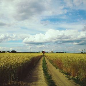 Scenic view of field against cloudy sky