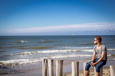 Woman standing on beach against sky