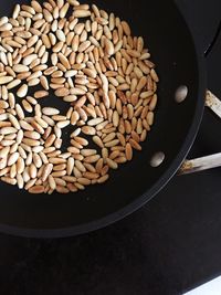 High angle view of pine nuts in a frying pan being roasted 