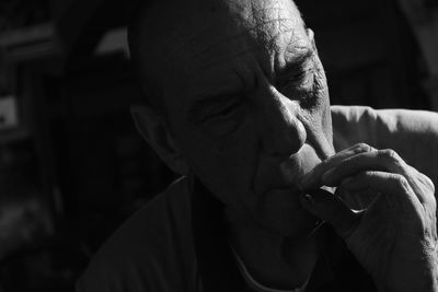 Close-up of man smoking cigarette in darkroom