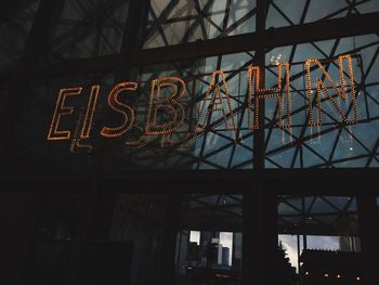 Low angle view of illuminated text on window