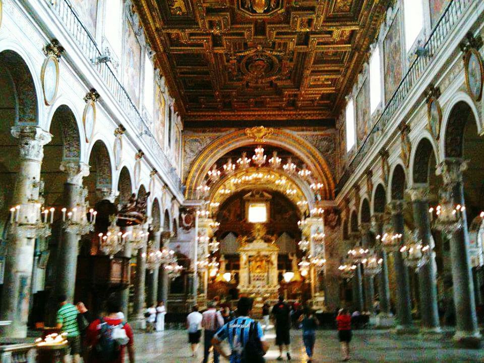 GROUP OF PEOPLE IN ILLUMINATED CATHEDRAL