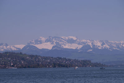 Scenic view of sea and mountains against clear sky