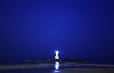 Lighthouse in city at night