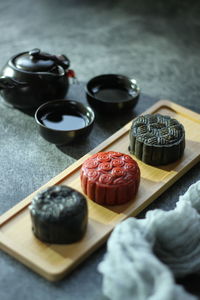 High angle of traditional red and black mooncake on the rough grey texture table.