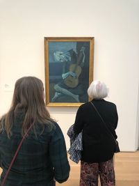 Rear view of woman standing against wall