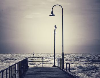 Street light on beach against clear sky