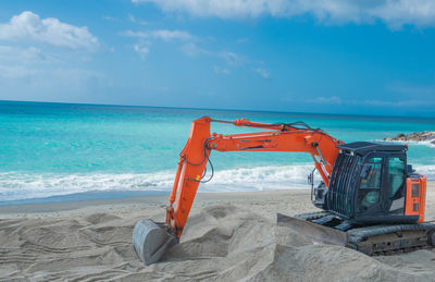 Excavator while it is clearing the beach