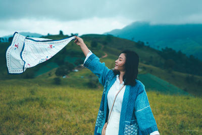 Woman standing on field against sky