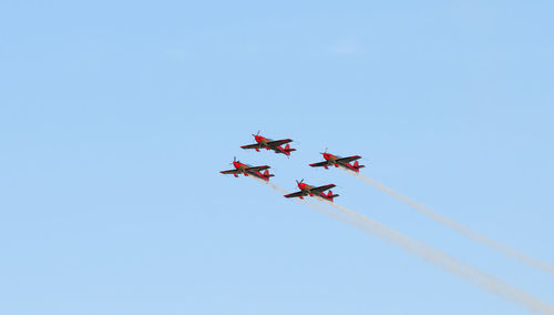 Low angle view of airshow against clear sky