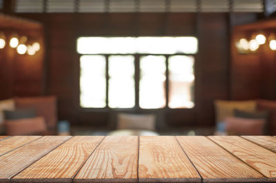 Close-up of empty wooden table in illuminated building
