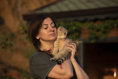 Portrait of young woman standing against trees