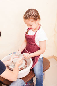 Cute girl using pottery wheel