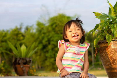 Portrait of smiling girl against plants