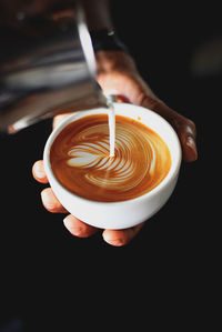 Cropped hands of man preparing coffee in cafe