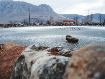 Surface level of lake against mountains during winter