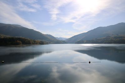 Scenic view of lake by mountains against sky