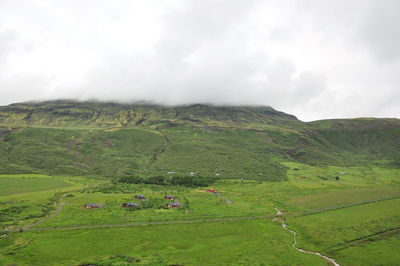 Scenic view of a river flowing between grass valleys