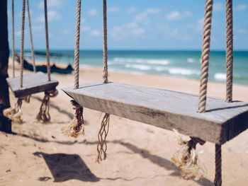 Close-up view of wooden swings on the beach on a sunny day