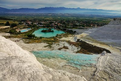 Scenic view of river by mountains against sky