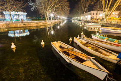 Boats moored in lake at night