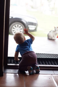 Rear view of boy playing in window