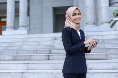 Smiling young woman using mobile phone