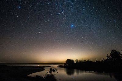 Scenic view of lake against sky at night