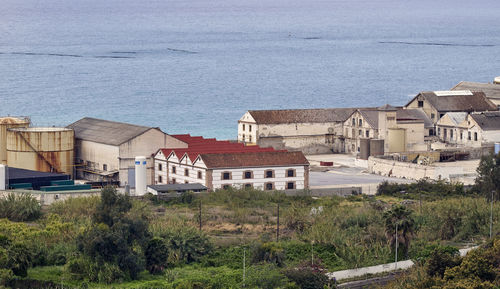 High angle view of buildings by sea against sky