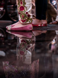 Low section of woman with buddha statue at temple