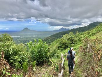 Rear view of people walking on mountain