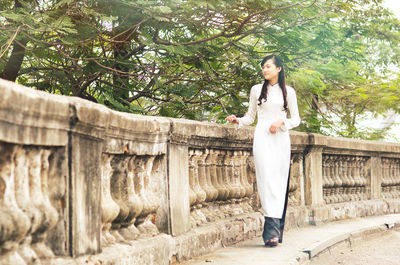 Young vietnamese girl walking in ao dai dress.