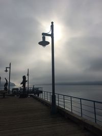 Silhouette pier by sea against sky
