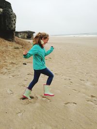 Side view of girl running at beach