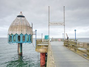 Pier on beach against sky