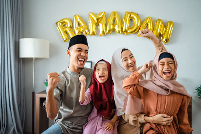 Portrait of smiling friends standing at home