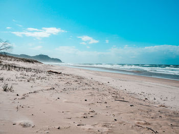 Scenic view of beach against blue sky