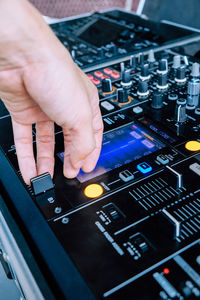 Close-up of cropped hand on control panel of turntable